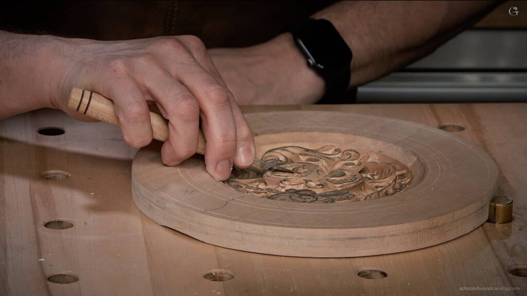 Artisan skillfully carving a butterfly design on a wooden plate using Northern European techniques