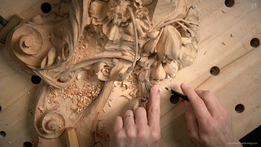 A person carving a piece of wood on a table.