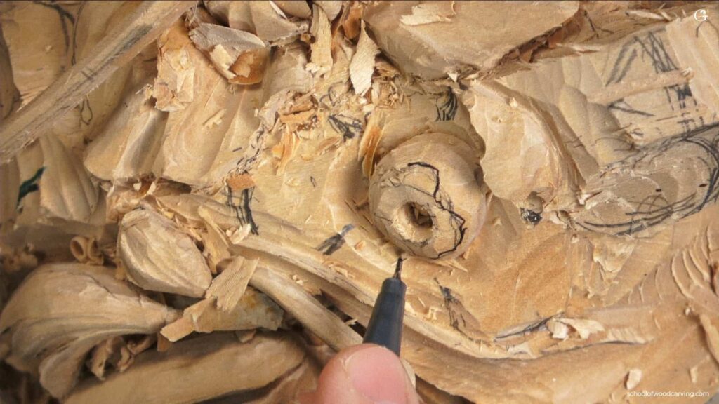 A person is using a pen to draw intricate woodwork in the Grinling Gibbons style.
