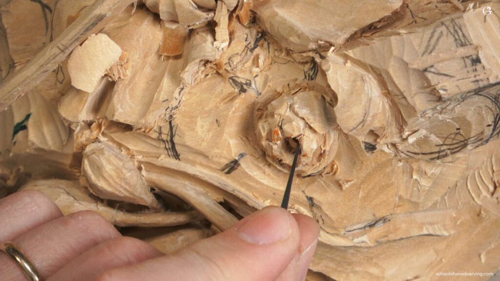A person is using a tool to make a wooden sculpture.