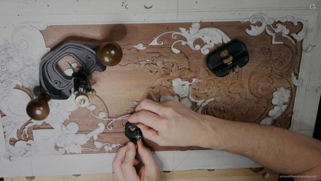A person is using a tool to make a design on a piece of wood.