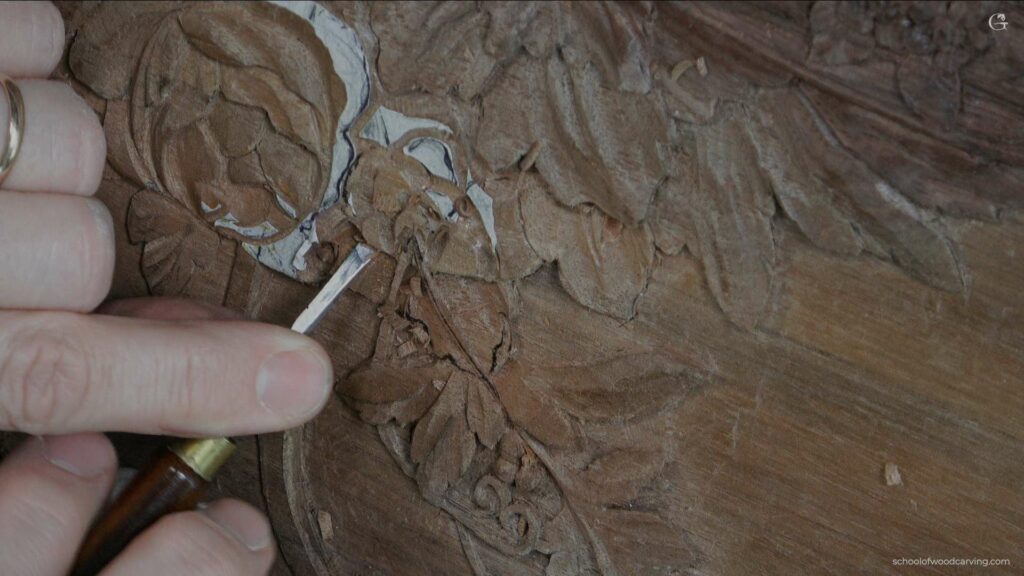 A person is using a tool to carve a piece of wood.