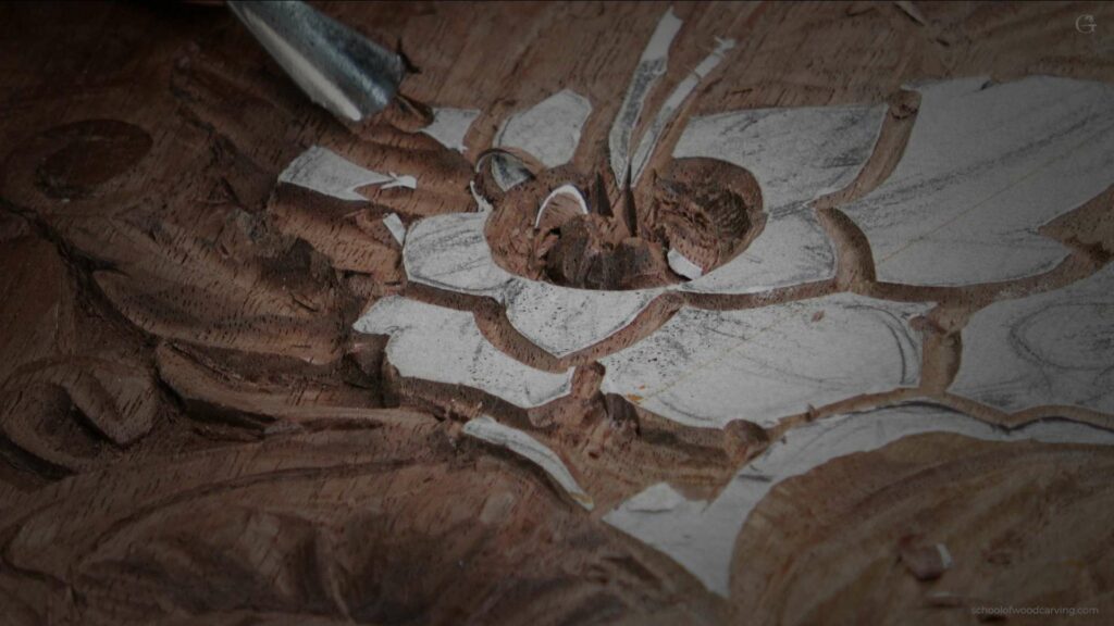 A person carving a flower on a piece of wood.
