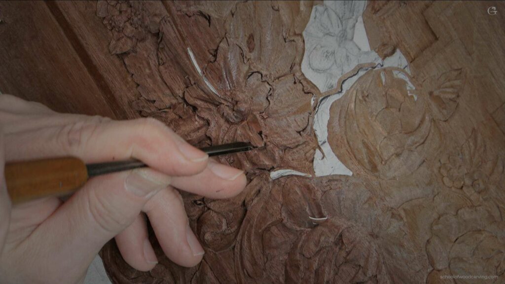 A person using a tool to carve a piece of wood.