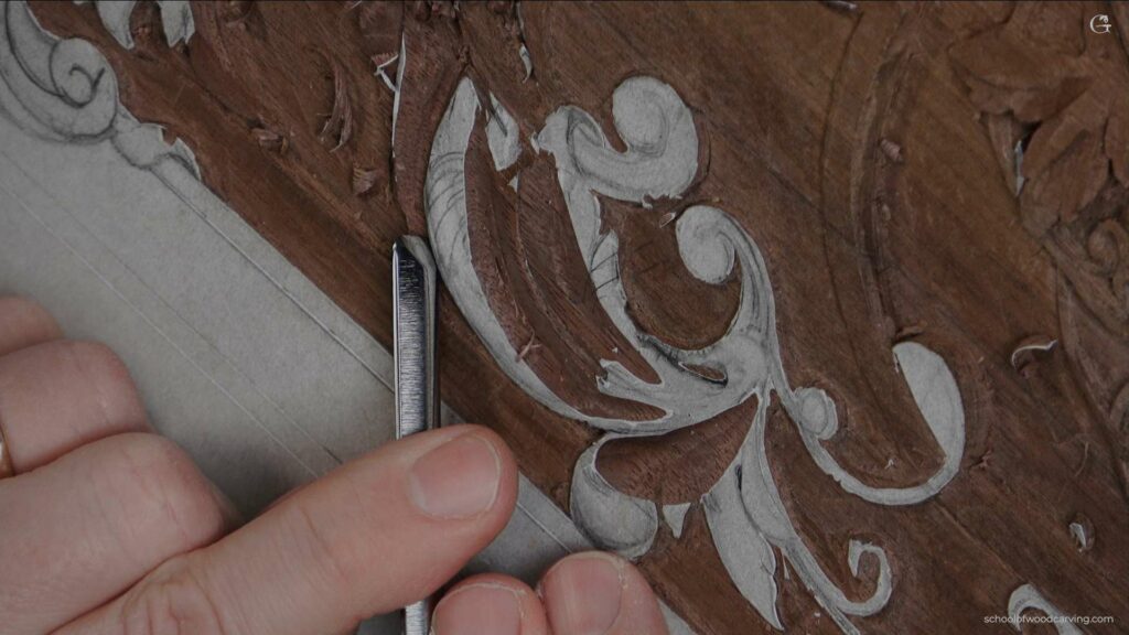 A person is using a tool to carve a design on a panel of wood.